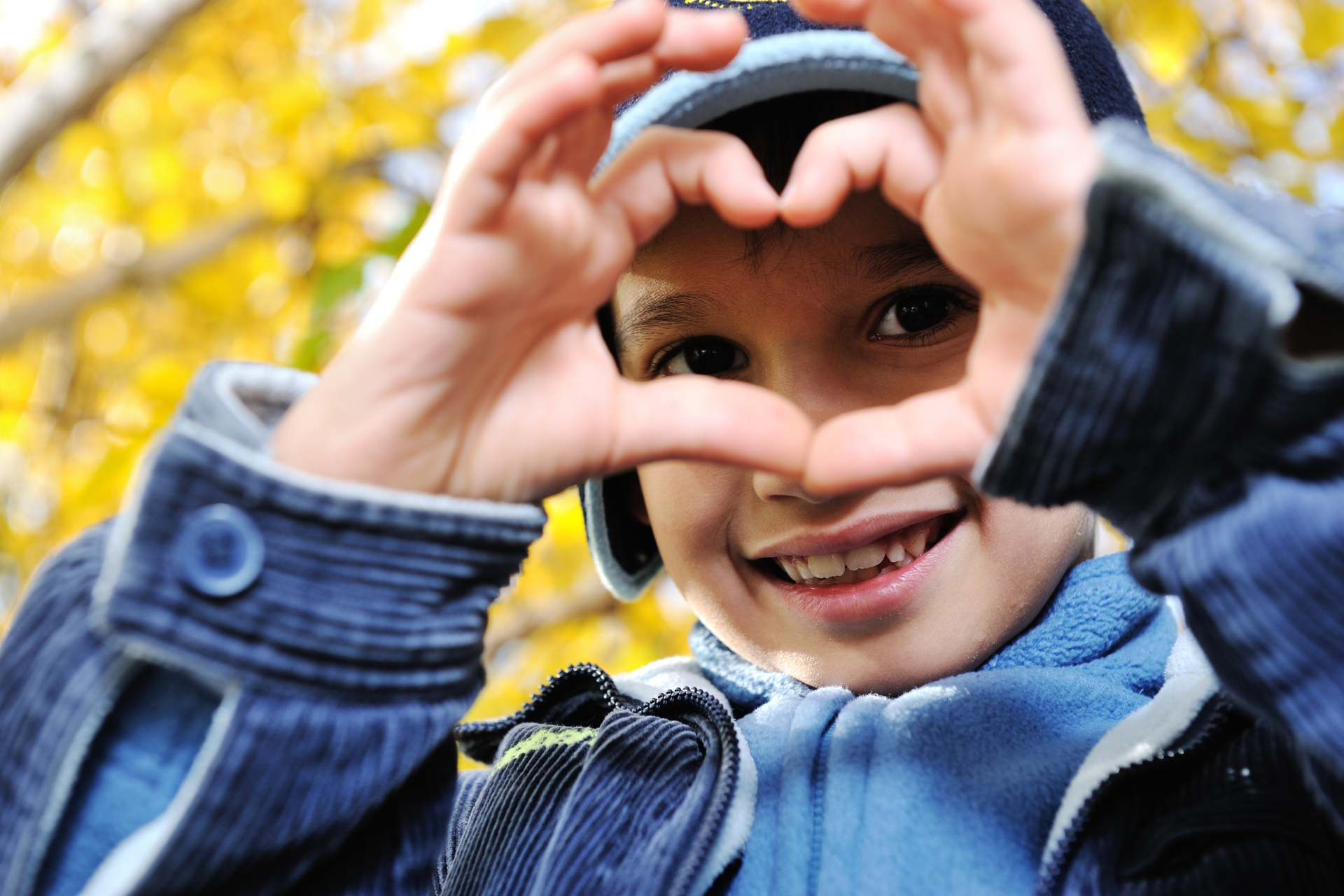 happy kids smiling young child making a heart with his hands