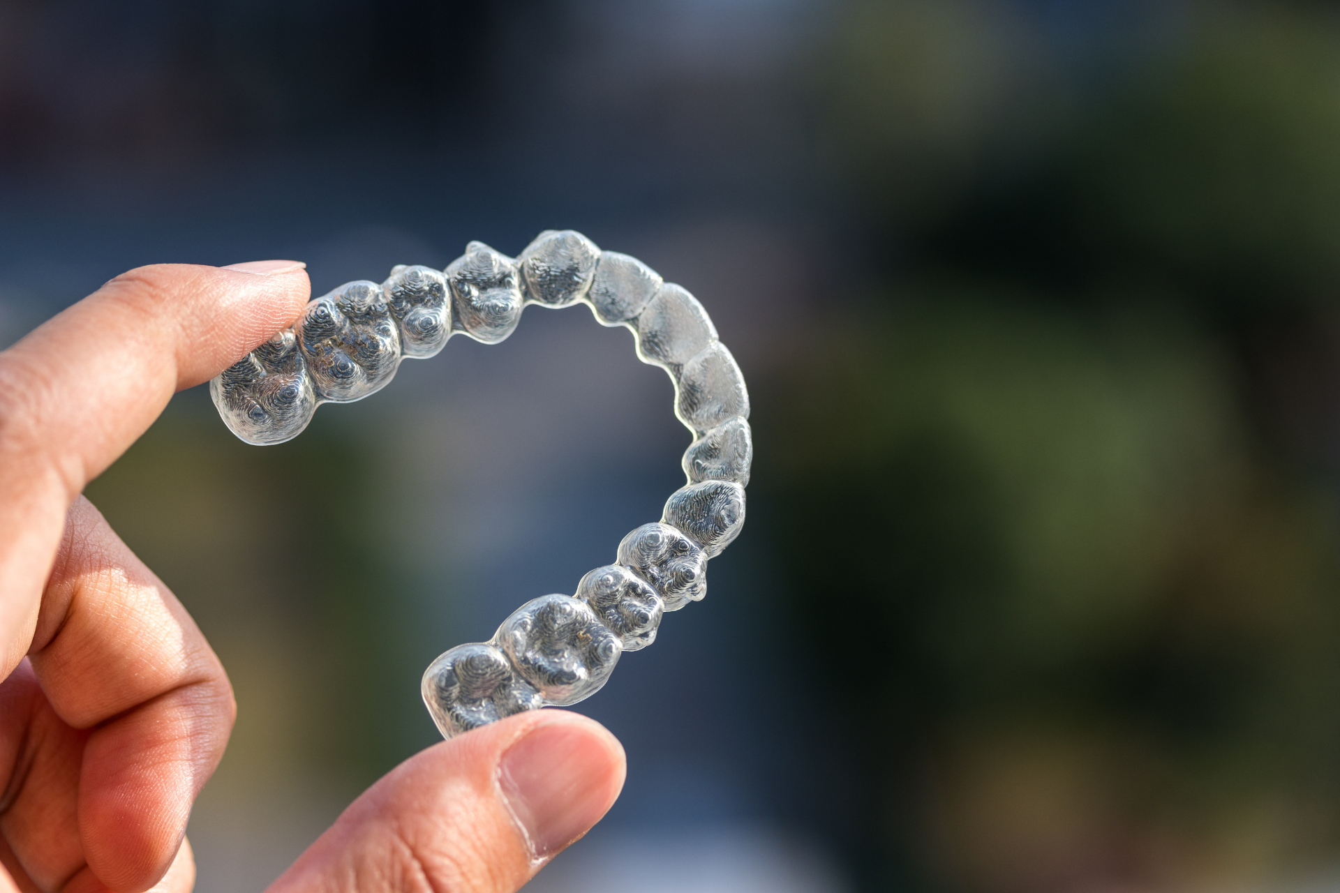 clear aligners being held up