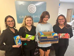 Great Smiles team members holding girl scout cookies