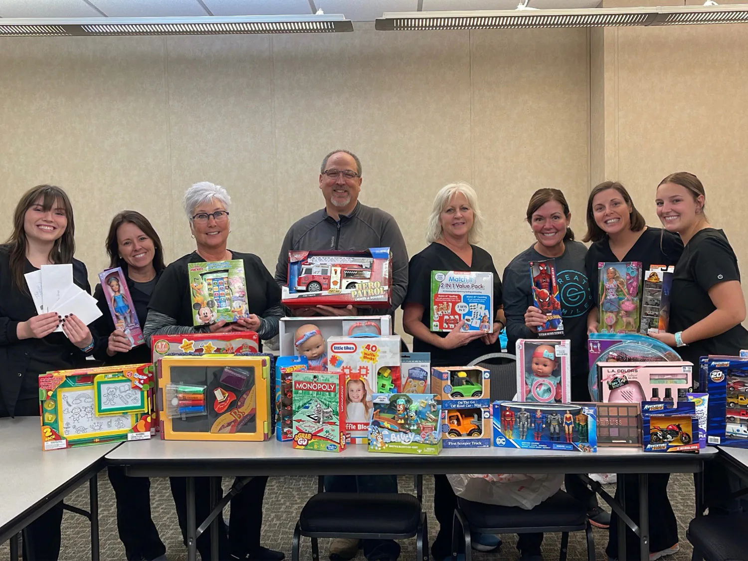 Great Smiles staff behind a table of toys